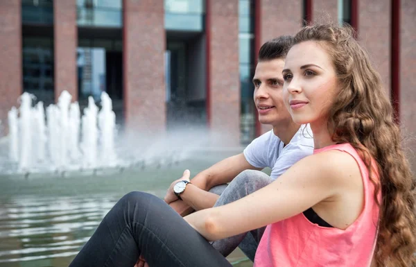 Pareja joven sentada al aire libre y hablando, concepto de felicidad —  Fotos de Stock