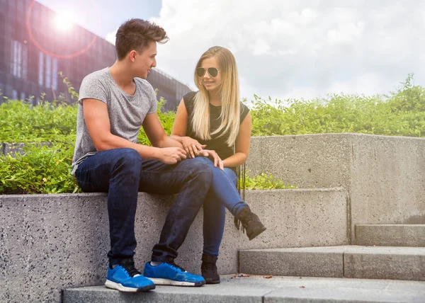 Jeune couple assis en plein air et parlant, concept de bonheur — Photo