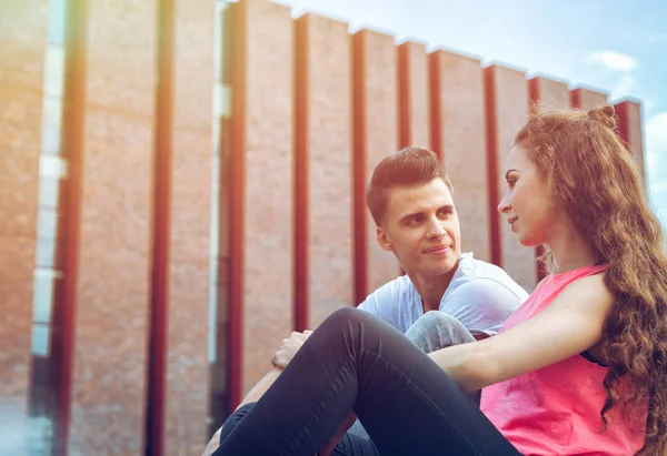 Jeune couple assis en plein air et parlant, concept de bonheur — Photo