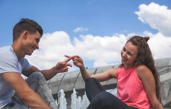 Pareja joven sentada al aire libre y hablando, concepto de felicidad — Foto de Stock