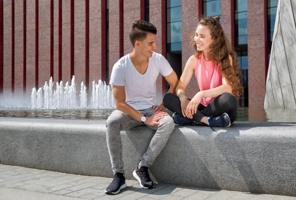 Молодая пара сидит на открытом воздухе и разговаривает, счастье концепции — стоковое фото