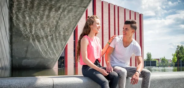Junges Paar sitzt draußen und redet, Glückskonzept — Stockfoto