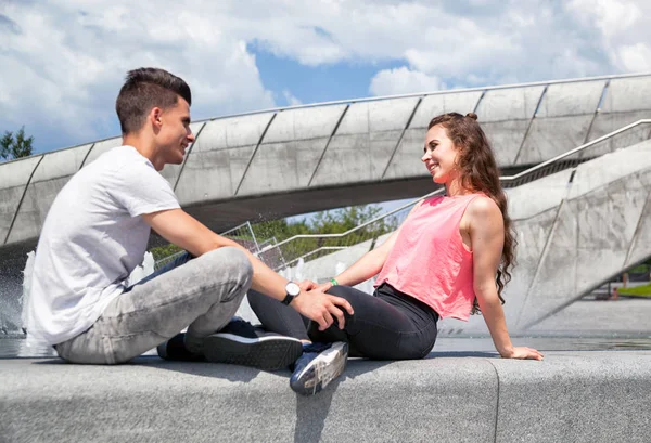 Молодая пара сидит на открытом воздухе и смеется, счастье концепции — стоковое фото