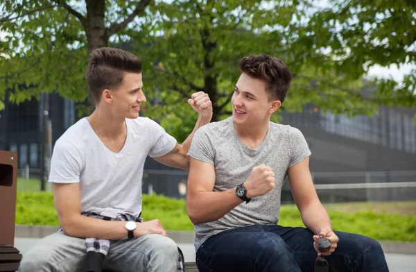 Two friends sitting on bench in town and talking, best friend — Stock Photo, Image