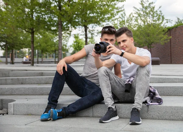 Dois amigos nas escadas da cidade com câmera e tirar fotos, melhor amigo — Fotografia de Stock