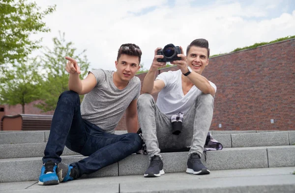 Two friends on stairs in town with camera and taking pictures, b — Stock Photo, Image