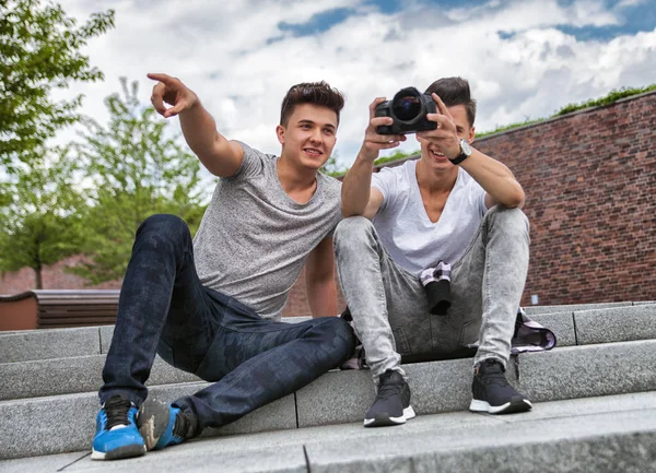Two friends on stairs in town with camera and taking pictures, best friend — Stock Photo, Image