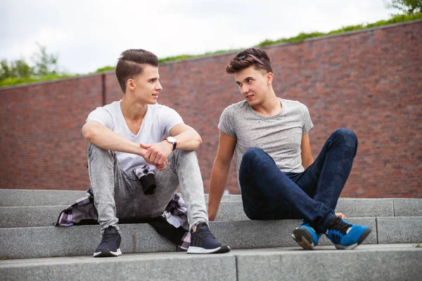 Dois amigos casual desgaste sentado em escadas na cidade e falando, melhor amigo — Fotografia de Stock