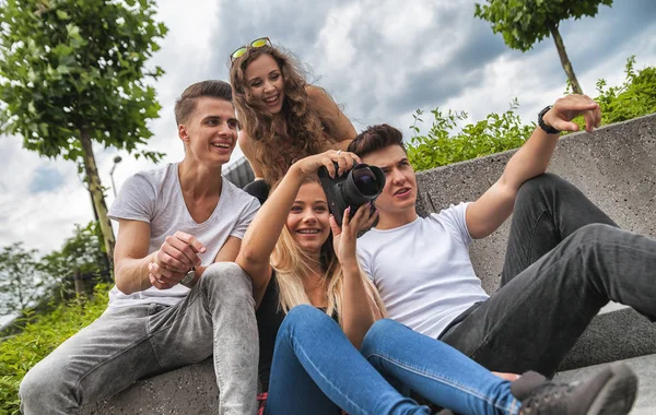 Group of friends sitting with camera and taking picture — Stock Photo, Image