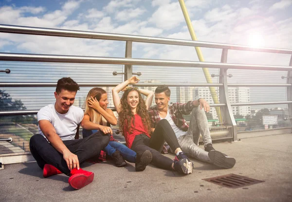 Skupina přátel sedí pohromadě venkovní na městské scenérie — Stock fotografie