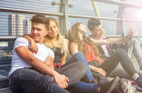 Group of friends sitting together outdoor on urban scenery — Stock Photo, Image