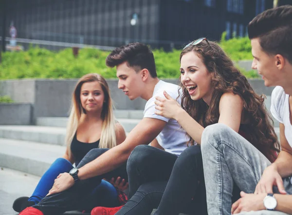 Группа друзей сидящих вместе на улице — стоковое фото
