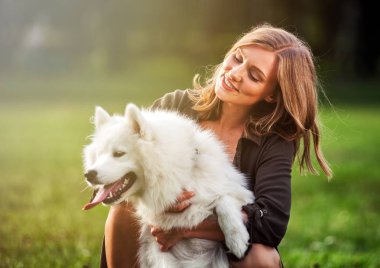 Sonra parkta, samoyed köpeğiyle oynamaya oldukça mutlu kız