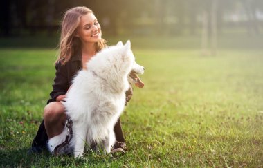 Sonra parkta, samoyed köpeğiyle oynamaya oldukça mutlu kız