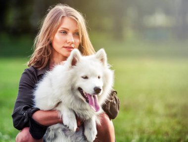 Sonra parkta, samoyed köpeğiyle oynamaya oldukça mutlu kız