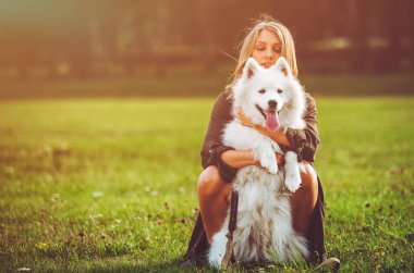 Güzel kız köpeğini parkta, samoyed ile oynarken