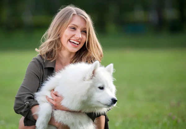 Sonra parkta, samoyed köpeğiyle oynamaya oldukça mutlu kız — Stok fotoğraf