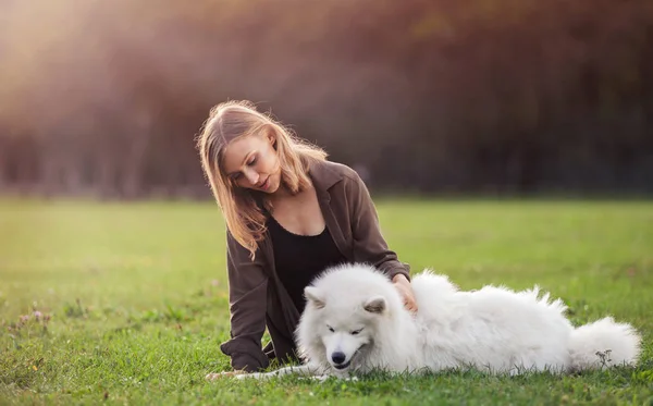 Jolie fille avec chien sur l'herbe — Photo