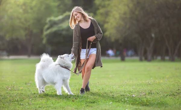 Hübsches Mädchen spielt und läuft mit Samthund im Park — Stockfoto