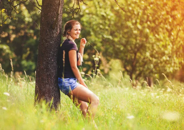 Hippie girl standing under tree on meadow at summer day — Stock Photo, Image