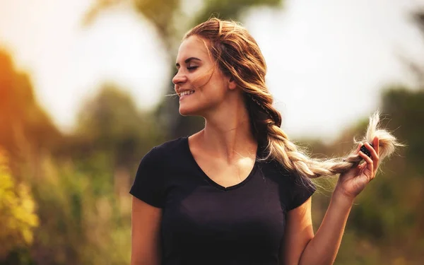 Mooie vrouw met vlecht glimlachend buitenshuis — Stockfoto