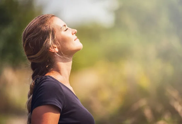 Mulher bonita com trança ao ar livre olhando para o sol e sorrindo — Fotografia de Stock