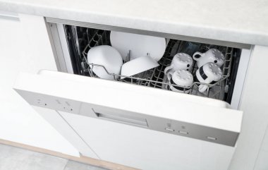 Temiz bulaşıklarla bulaşık makinesini aç.