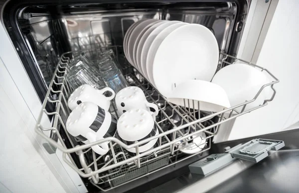 Open dishwasher with clean dishes close up