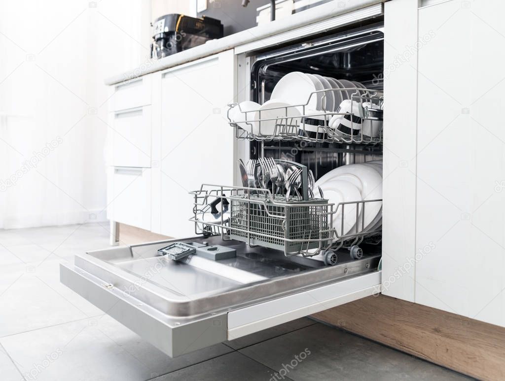 Open dishwasher with clean dishes in white kitchen