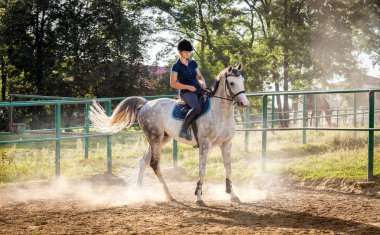 Padok üzerinde toz içinde bir binicilik kadın