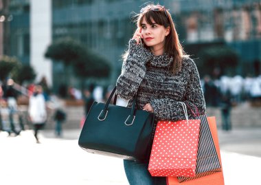 Alışveriş torbaları istimal hareket eden telefon, şehir sahne olan kadın