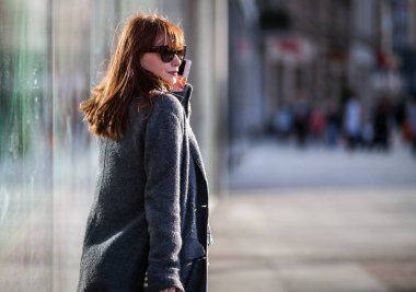 Cep telefonu kullaranarak sokakta acele kadın