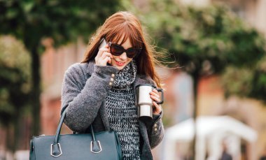 Gülümseyen kadın şehirde cep telefonunda söz