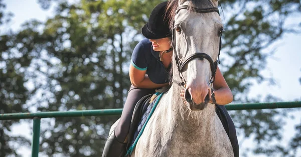 Mujer montando un caballo en el paddock, ropa deportiva de mujer a caballo — Foto de Stock