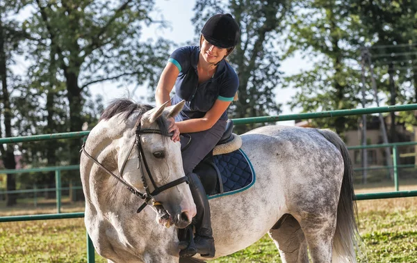 Žena, jízda na koni na paddock, jezdkyně sportovní oblečení — Stock fotografie