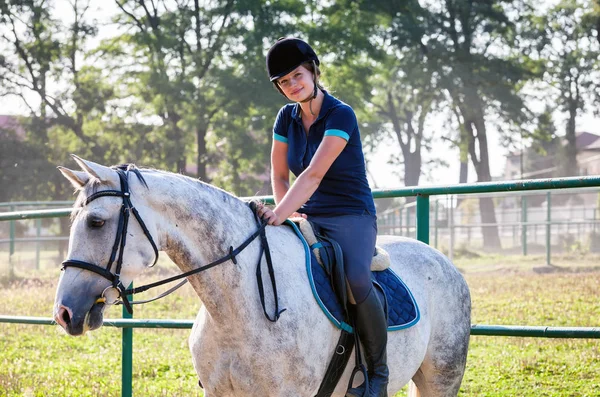 Woman riding a horse on paddock, horsewoman sport wear — Stock Photo, Image