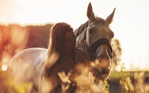 Woman with her horse at sunset, autumn scene — Stock Photo, Image