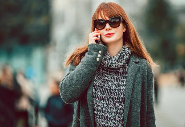 Junges Mädchen im Mantel mit Handy auf der Stadtstraße — Stockfoto