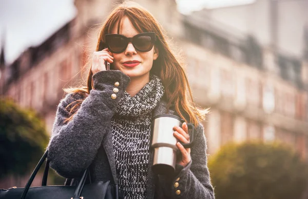 Kobieta z filiżanki kawy, rozmowy na telefon komórkowy w mieście — Zdjęcie stockowe