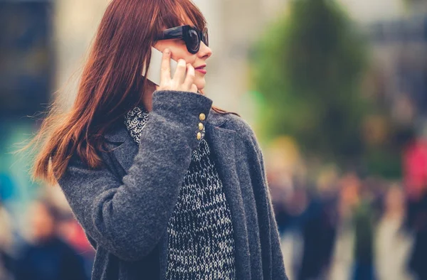 Жінка в місті розмовляє по мобільному телефону — стокове фото