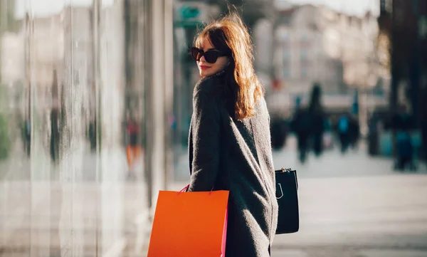 Mujer durante el paseo por la calle con bolsas de compras —  Fotos de Stock