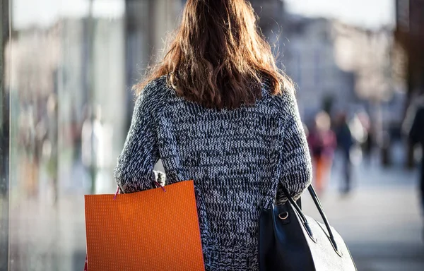 女性の買い物袋が付いている通りを散歩中に — ストック写真