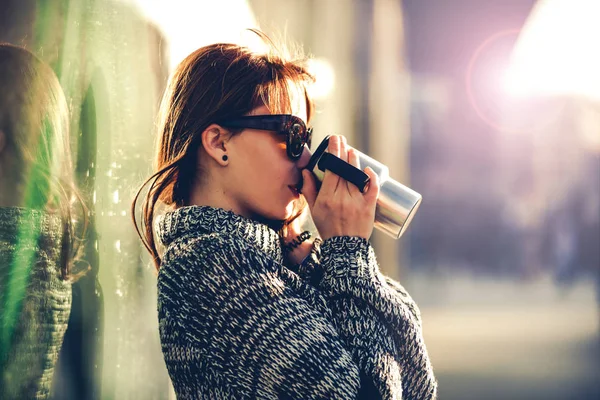 Kvinna som dricker kaffe stående på gatan — Stockfoto