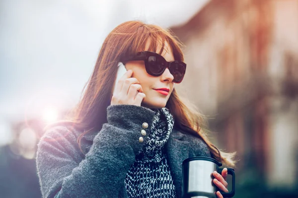 Міська сцена, жінка з чашкою кави розмовляє на мобільний телефон у місті — стокове фото