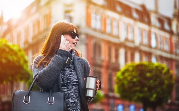 Escena urbana, mujer con taza de café hablando por teléfono móvil en la ciudad — Foto de Stock