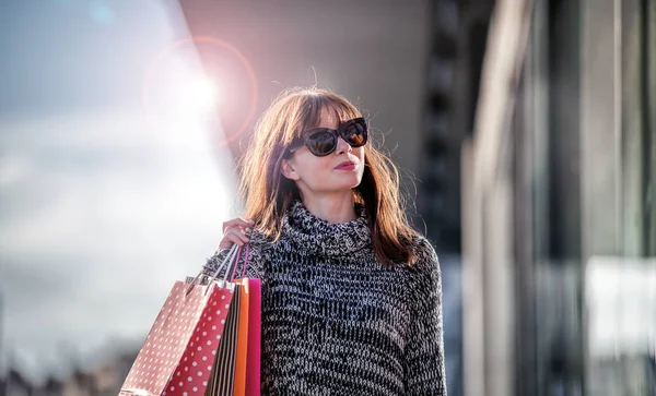 Cena urbana, mulher caminha na rua com sacos de compras — Fotografia de Stock