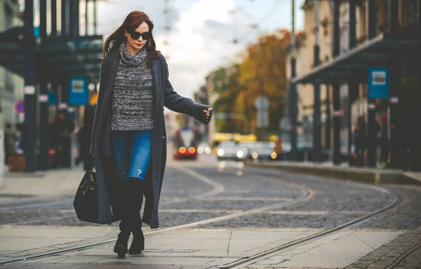 Trendy mode vrouw in jas lopen op de straat, stad scène — Stockfoto