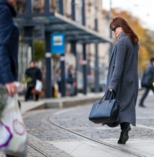 Trendy donna di moda in cappotto a piedi per strada, scena della città — Foto Stock
