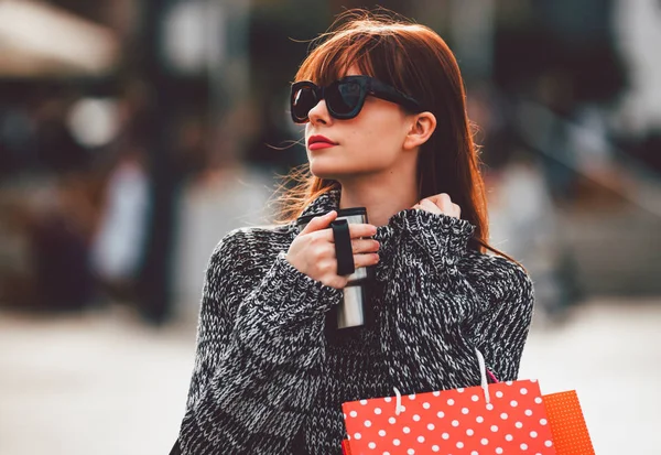 Mujer caminando por la calle con taza de café y bolsas de compras, concepto de vida de la ciudad —  Fotos de Stock