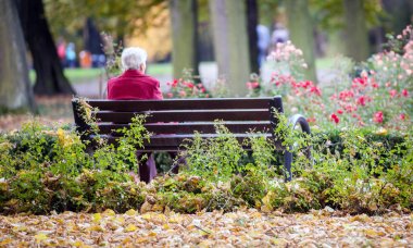 Depresyonda ve üzgün eski yalnız parkta bankta oturan kadın